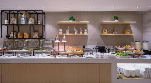 a buffet line in a restaurant with food on display at City Comfort Inn Beihai RT-Mart High Speed Railway Station in Beihai