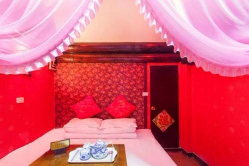 a red room with a bed with red walls at Pingyao Yufengheng Hotel in Pingyao