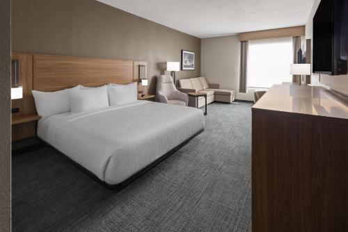 a hotel room with a bed and a couch and chair at La Quinta Inn & Suites by Wyndham Phoenix West Glendale in Phoenix