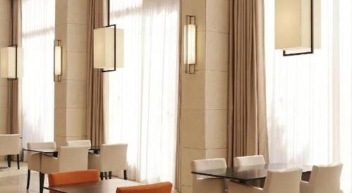 a dining room with white chairs and tables and windows at Top Cloud Hotel Iksan in Iksan