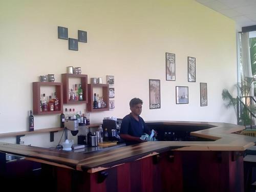 a man sitting at a bar in a coffee shop at Brook Boutique in Sigiriya