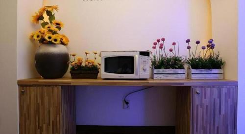 a table with a microwave and flowers in a vase at Java Hotel in Daejeon