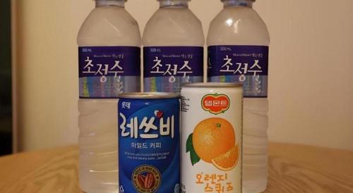 three bottles of orange water sitting on a table at Java Hotel in Daejeon