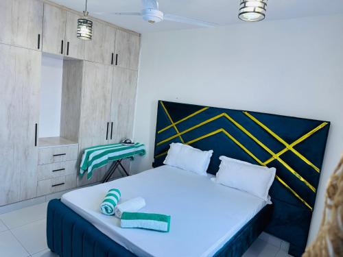 a bedroom with a bed with a blue and yellow headboard at Gianas stays Nyali in Mombasa