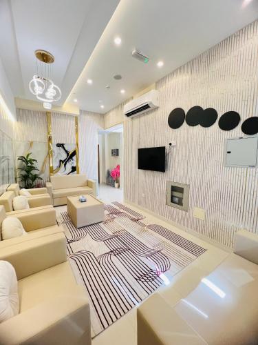 a living room with couches and a tv on a wall at Town Plaza Hotel Apartments Ras Al Khaimah in Ras al Khaimah