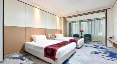 a hotel room with two beds and a desk at Dalian Bohai Pearl Hotel in Dalian