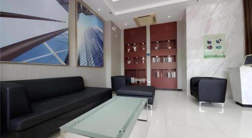 a living room with a black couch and a glass table at City Comfort Inn Zhaoqing Qixingyan Scenic Area Xinghu Archway in Zhaoqing
