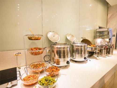 a kitchen with bowls of food on a counter at City Comfort Inn Wuhan High Speed Railway Station in Wuhan