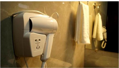 a hair dryer on a wall in a bathroom at Staynest Continetal With parking Near Mg Marg in Gangtok