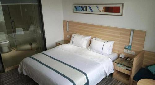 a hotel room with a bed and a shower at City Comfort Inn Zhaoqing Qixingyan Scenic Area Xinghu Archway in Zhaoqing