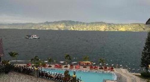 a view of a large body of water with a swimming pool at Samosir Cottages Resort in Tuk Tuk