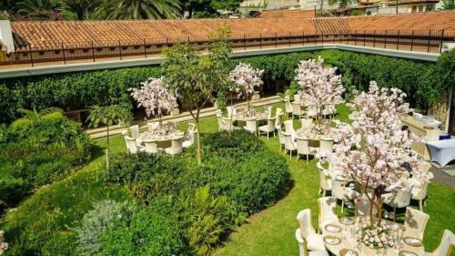 a garden with white tables and chairs and trees at Hotel Casa Suwon in Suwon
