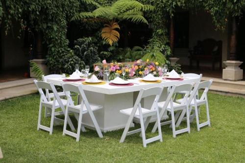 a white table with white chairs and flowers on it at Hotel Casa Suwon in Suwon