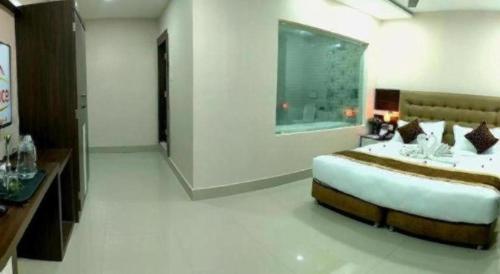 a bedroom with a large bed and a window at Hotel Gajur Palace in Itahari