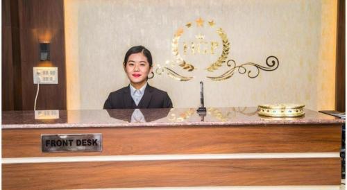 a woman is sitting at a front desk at Hotel Gajur Palace in Itahari
