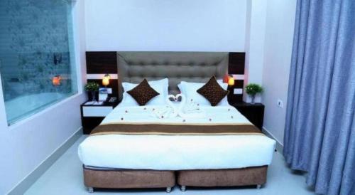 a bedroom with a large bed and blue curtains at Hotel Gajur Palace in Itahari