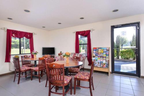 a dining room with a table and chairs and a television at Baymont by Wyndham Acworth in Acworth
