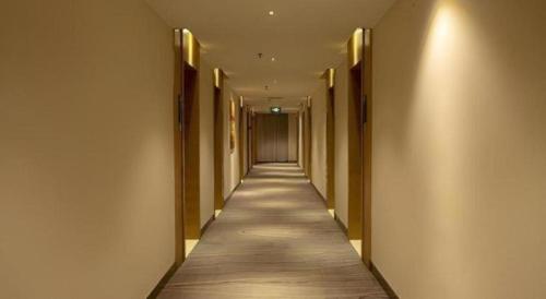 a hallway with a long aisle with a hallwayngthngthngthngthngthngthngth at City Comfort Inn Nanning Zoo Keyuan Avenue in Nanning