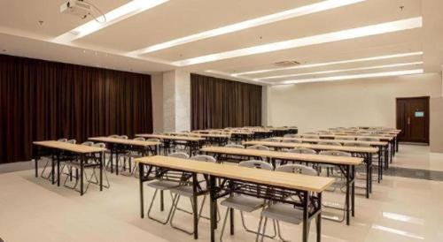 a classroom with tables and chairs in a room at City Comfort Inn Nanning Zoo Keyuan Avenue in Nanning