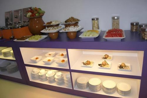 a display case filled with different types of food at Oriza Hotel Surabaya in Surabaya