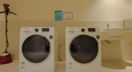 two washing machines sitting next to each other in a room at City Comfort Inn Nanning Zoo Keyuan Avenue in Nanning