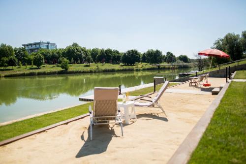 a couple of chairs and a table next to a river at Hotel Kormorán in Šamorín