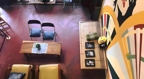 a room with chairs and a table and a wall with graffiti at Oldie and Sleepy Hostel in Udon Thani