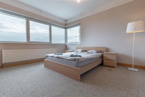 a bedroom with a bed in a room with windows at Comfort & Views over Riga Apartment near Airport and City Center in Rīga