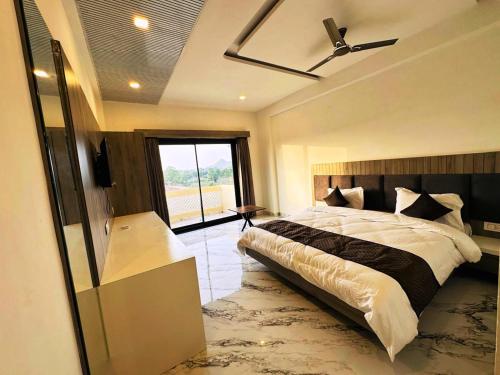 a bedroom with a bed and a ceiling fan at Horizon Banquet Pushkar - with Mountain View in Pushkar