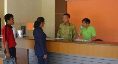 a group of people standing at a counter at The Luxio Hotel in Sorong