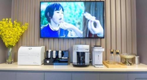 a tv sitting on a counter with a coffee maker on it at Home Inn Selected Xiamen University Zhongshan Road in Xiamen
