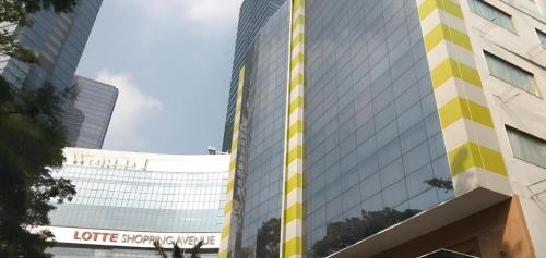 a tall building with yellow and white stripes on it at An Hotel Jakarta in Jakarta