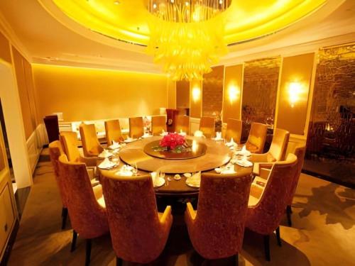 a dining room with a table with chairs and a chandelier at Changchun Zhuozhan Days Hotel in Changchun