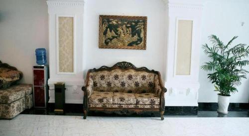 a room with a couch and a painting on the wall at Hanoi Milan Hotel in Hanoi