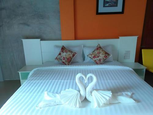 two white swans forming a heart on a bed at Waenpetch place Hotel in Ubon Ratchathani
