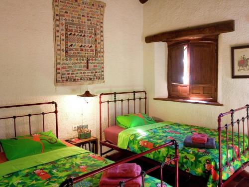 a bedroom with two beds and a window at Tranquil Riverside Retreat in Alájar