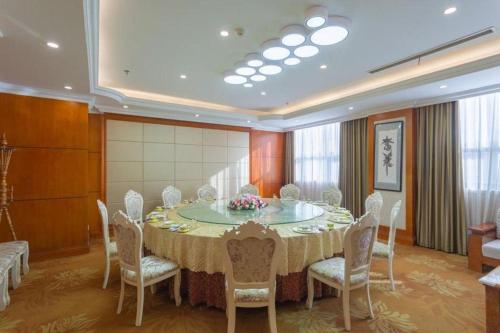 a dining room with a table and chairs and a room with a table and chairs at Vienna Classic Hotel Qingdao Huangdao in Huangdao