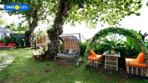 a group of chairs sitting under a tree at Double G Resort Anyer in Carita