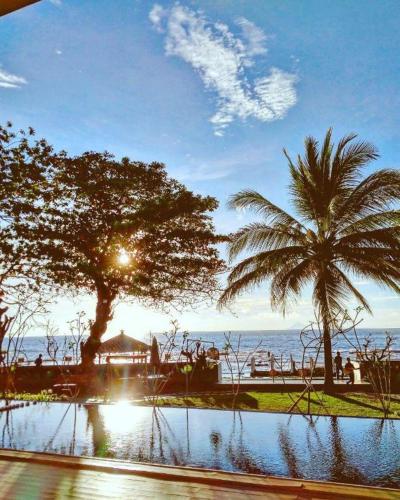 a view of the ocean from a resort with palm trees at Double G Resort Anyer in Carita