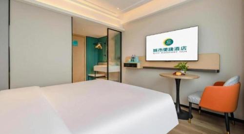 a bedroom with a white bed and a table and a tv at City Comfort Inn Nanning Guangxi University in Nanning