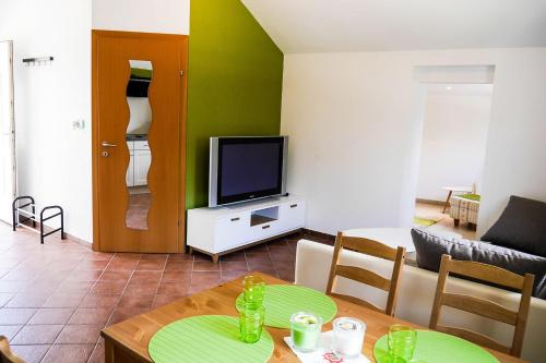 ein Wohnzimmer mit Tisch und Fernseher in der Unterkunft Millenium Inn in Mürzzuschlag