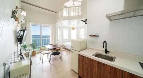 a kitchen with a sink and a table in a room at Gallery Pension in Taean