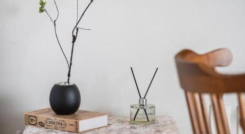 a table with a black vase on a book and a vase at Gallery Pension in Taean