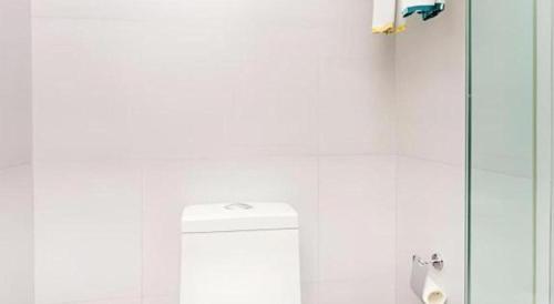 a white bathroom with a toilet and a shower at City Comfort Inn Xiangyang Railway Station in Xiangyang