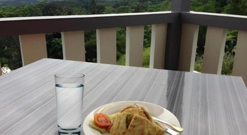 a plate of food and a glass of water on a table at Fafa Hill Hotel and Resort in Bogor