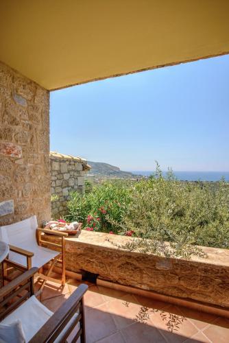 a patio with a table and a view of the ocean at Orfea's Place in Riglia