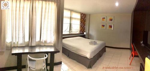a bedroom with a bed and a window at Huern Che Ta One Hotel in Phrae