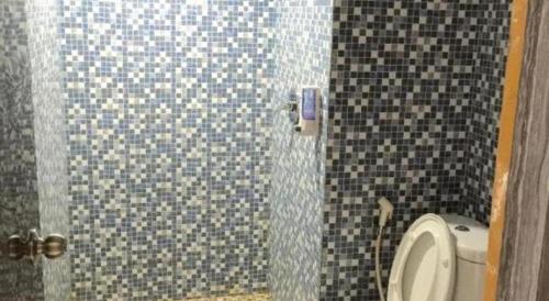 a bathroom with a shower with a toilet in it at Hotel 95 in Pontianak