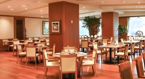 a dining room filled with tables and chairs at Jeju Sejong Hotel in Jeju