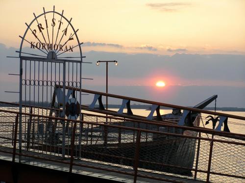 a view of a pier with the sunset in the background at Hotel Kormorán in Šamorín
